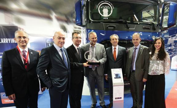 Ο υφυπουργός Μεταφορών κ. Νίκος Μαυραγάνης (στο κέντρο) απονέμει το τρόπαιο του φορτηγού της χρονιάς στον αντιπρόεδρο της Ford Trucks κ. Serhan Turfan (αριστερά του). Μαζί τους ο κ. Selim Yazici (δι/νων σύμβουλος αν. Ευρώπης και Βαλκανίων της Ford Trucks), ο κ. Νίκος Πατσατζής (δι/νων σύμβουλος Ergotrak – δεύτερος από αριστερά), ο κ. Emrah Duman (διευθυντής διεθνών αγορών Ford Trucks), ο Γενικός Γραμματέας του υπ. Μεταφορών κ. Θάνος Βούρδας και η Θάλεια Αγριμανάκη (διοργανώτρια της Transport Show).